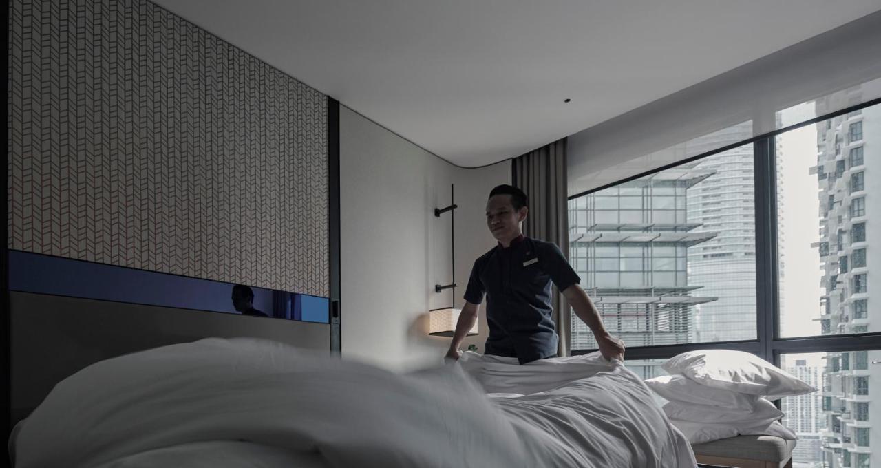Amari Kuala Lumpur Hotel Exterior foto A hotel housekeeper making a bed